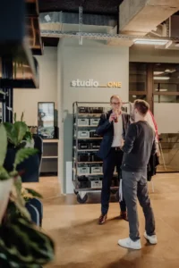 Zwei Personen unterhalten sich in einem modernen Büro bei einer Veranstaltung.