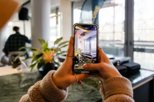 Person fotografiert einen Raum mit dem Smartphone bei einer Veranstaltung.