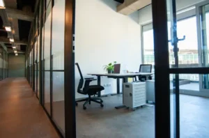 Moderner Arbeitsplatz mit Schreibtisch, Laptop und Bürostuhl in einem hellen Büro.