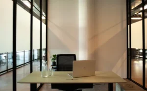 Minimalistischer Schreibtisch mit Laptop und Pflanze in einem ruhigen Büro.