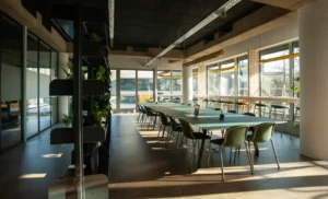 Großer Gemeinschaftstisch in einer modernen Büro-Küche mit viel Tageslicht.