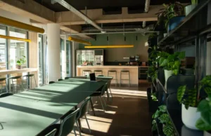 Offene Büroküche mit Sitzplätzen und Arbeitsbereich in modernem Design.