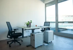 Moderner Arbeitsplatz mit Schreibtisch, Laptop und Bürostuhl in einem hellen Büro.