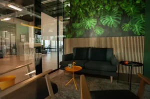 Gemütliche Sitzecke mit Sofa und Pflanzen in einem modernen Bürobereich.