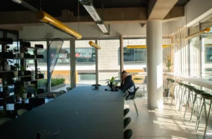 Offener Arbeitsbereich mit langen Tischen und Sitzplätzen in einem Büro.